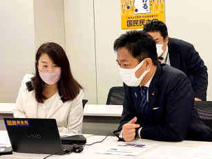 オンラインで参加している当事者の小野春さんが写るパソコンの画面を見つめる玉木議員と矢田さん