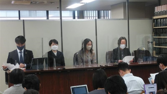 霞が関の司法記者クラブで記者会見に臨む原告の小野さん、西川さん、弁護団の上杉さん、沢崎さん。大勢の記者を前にして机に座っている