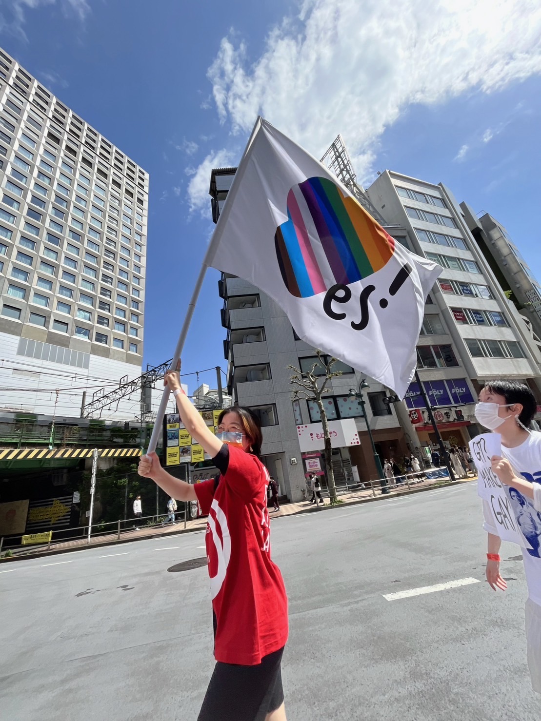 マリフォーインターン、小野関友佳さんが、東京レインボープライド2023のプライドパレードで「結婚の平等にYES！」のハートフラッグを掲げている写真