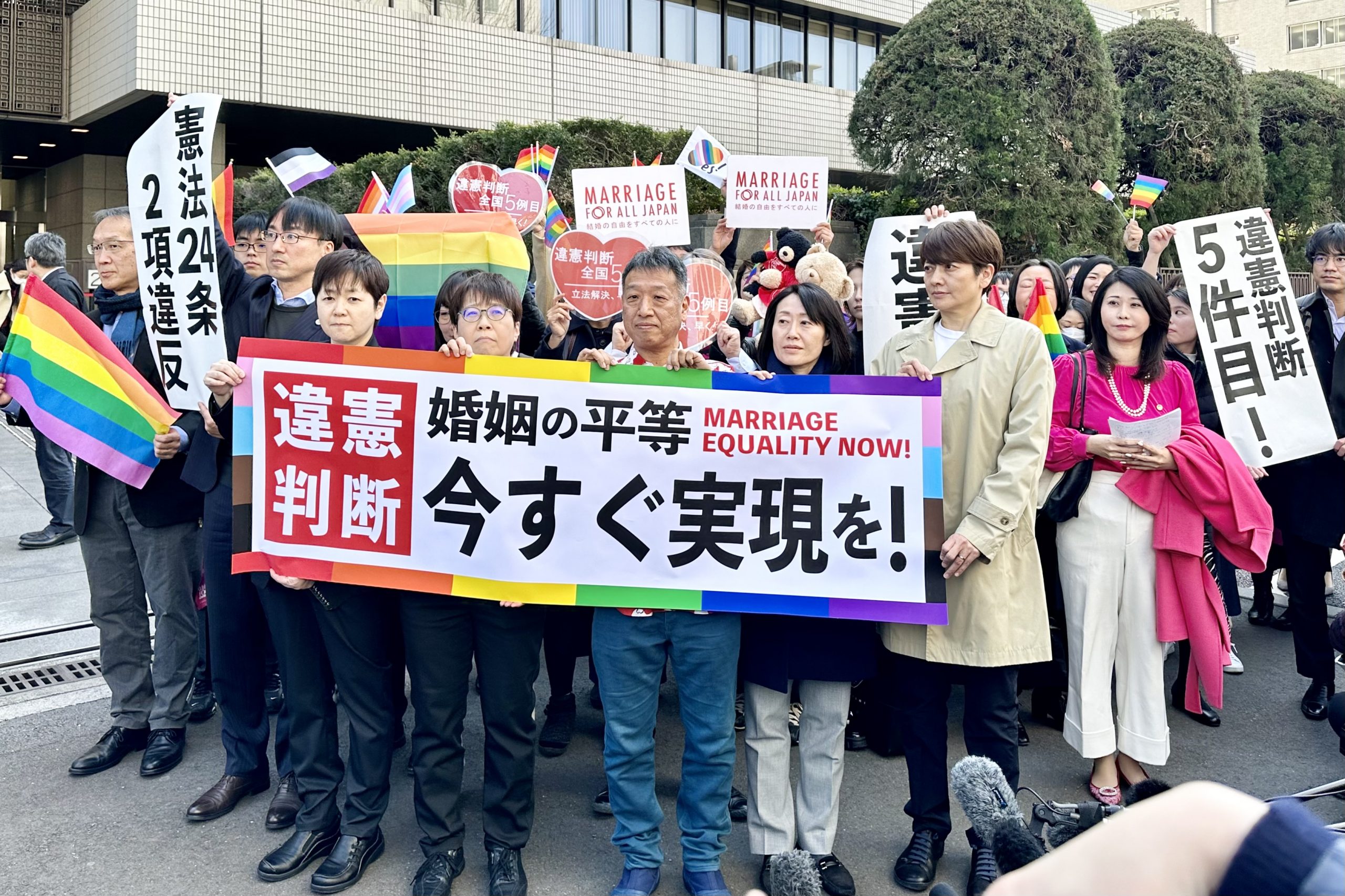 「結婚の自由をすべての人に」東京第二次訴訟 東京地裁判決後の旗出し風景。原告らが掲げる旗には「違憲判断 婚姻の平等 今すぐ実現を！ Marriage Equality Now」と書かれている