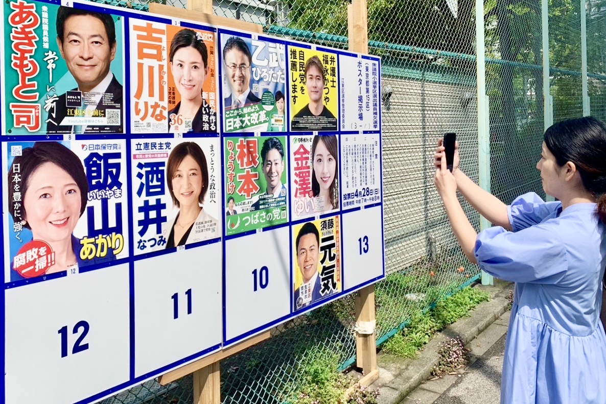 衆議院議員補欠選挙 東京15区選挙ポスター前でスマートフォンをかざし「PRIDE VISION」を試すユーザー