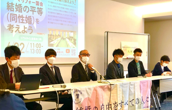 雨が降る中　結婚の自由をすべての人に九州訴訟と書かれたボードを持って、裁判所に向かう原告さんたち 