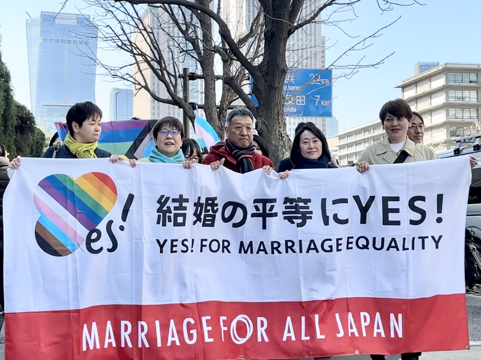 東京地方裁判所前で旗を持ちながら行進する「結婚の自由をすべての人に」訴訟 東京二次原告らと弁護団員