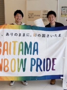 埼玉レインボープライドの横断幕を持つ稲垣さんと立崎さん　