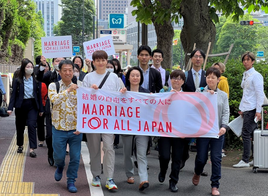 東京地方裁判所に入廷する原告団と弁護団 「結婚の自由をすべての人に」というフラッグを持っている