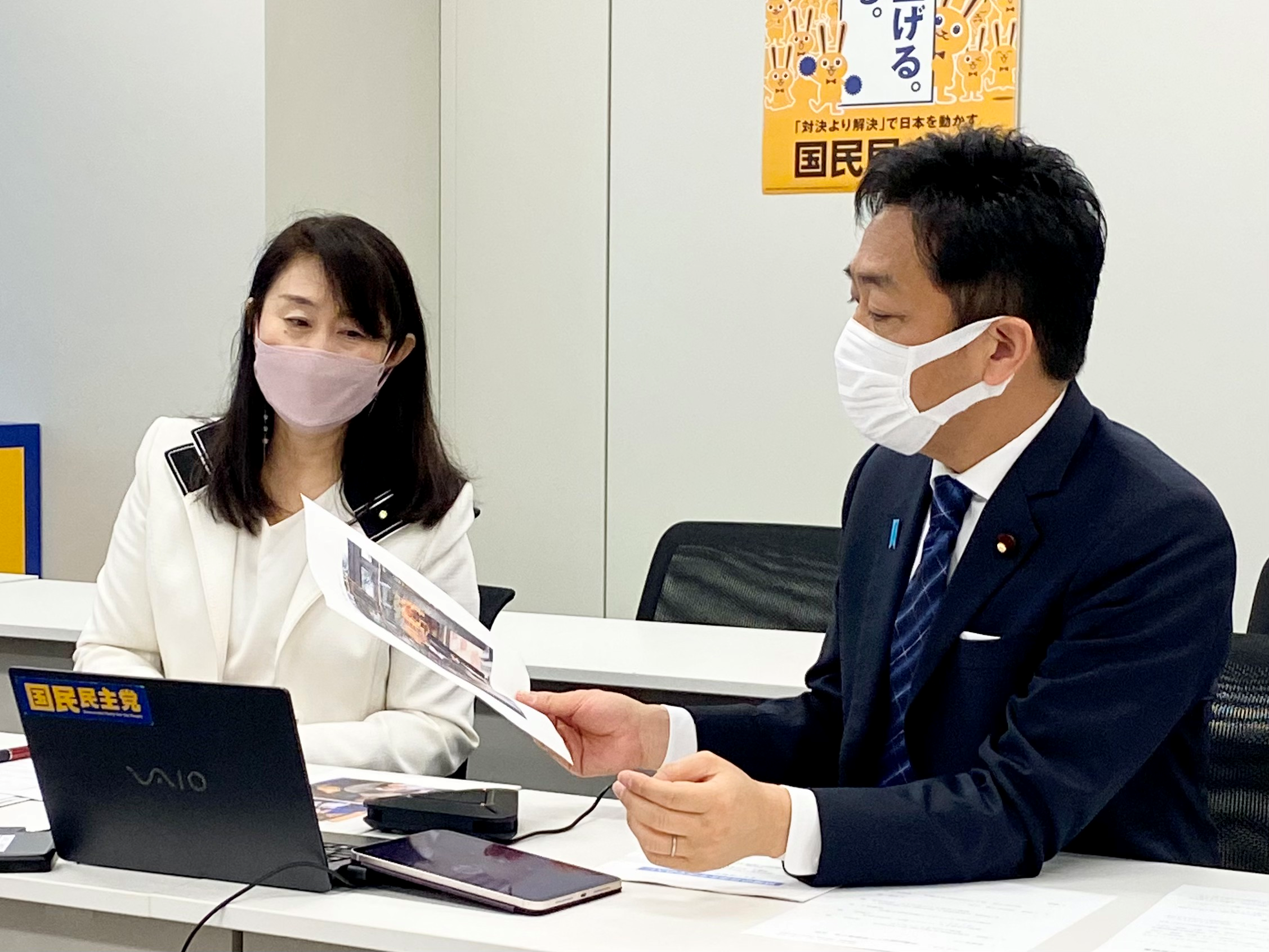 坂田テレサさん、麻智さんカップルの写真を見る玉木議員と矢田さん