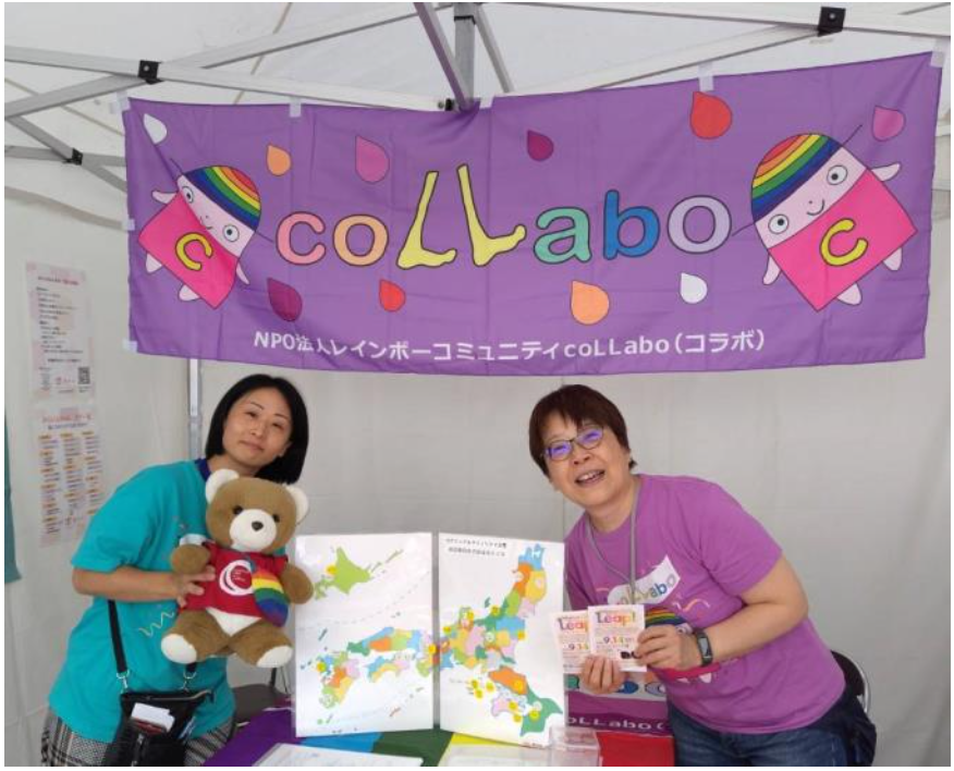 coLLabaoという団体のブース内の写真。 スタッフさん二人とくまが、記念撮影をしている。
