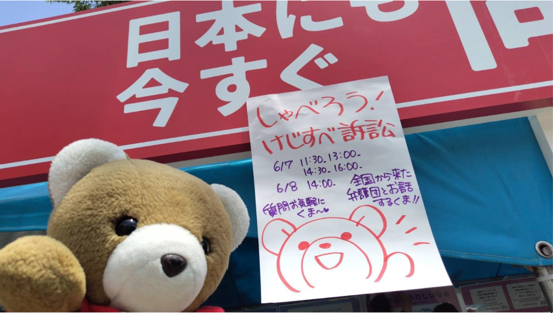 「しゃべろう！けじすべ訴訟」と書かれた手書きのチラシとマリフォーくまちゃんの写真