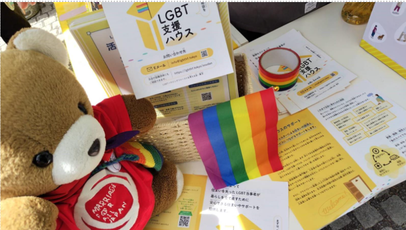 LGBT支援ハウスのブースに置かれたパンフレットを眺めるくまちゃん。