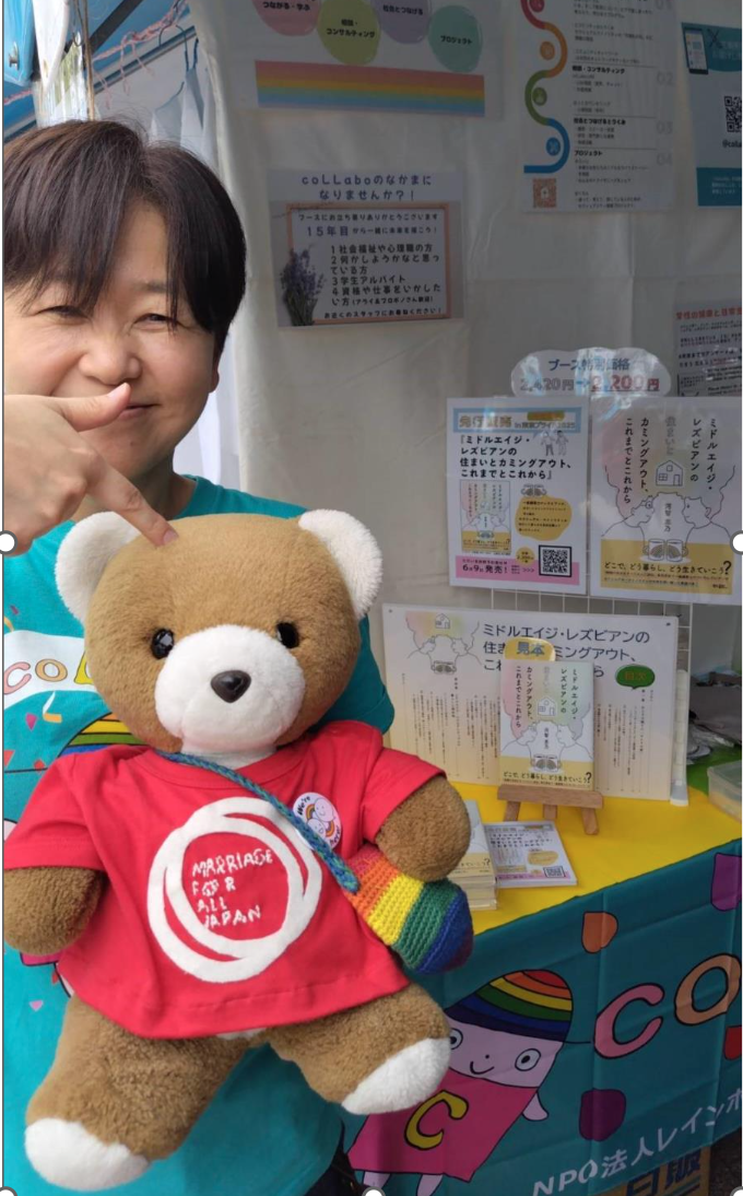 coLLaboのブース前で、原告河智さんとクマちゃんが仲良くポーズをとる写真