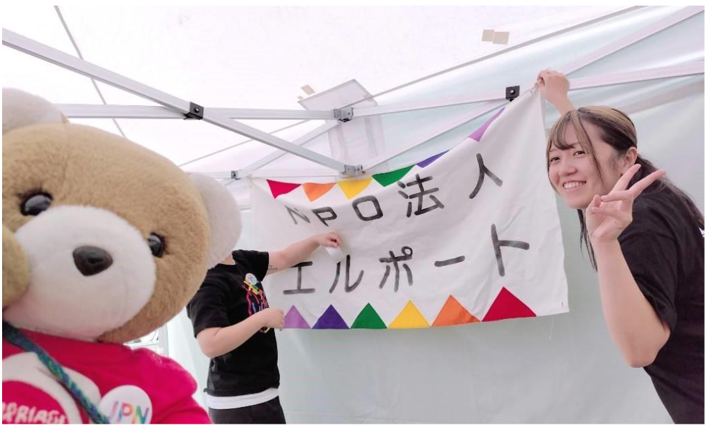 テント内に、北海道訴訟原告のえりさんCさんがおり、NPO法人エルポートと書かれた旗を設置している。 くまちゃんは、うまいこと自分の耳でCさんの顔を隠している。