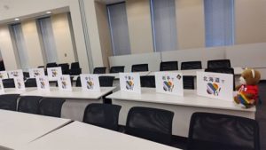 マリフォー国会の設営風景。くまちゃんが、テーブルの上にパネルを並べている。