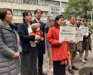 最高裁の西門前に、各地の弁護団めえんばーや原告が立って、取材を受けている。 原告さんは、プラカードを持っていて、特別じゃなくて普通が欲しい、みんなが選べるように私たちも選びたい、などのメッセージが書かれている。