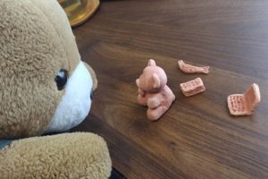 くまが自宅で粘土遊びをしている。粘土は、くまの形をしている。